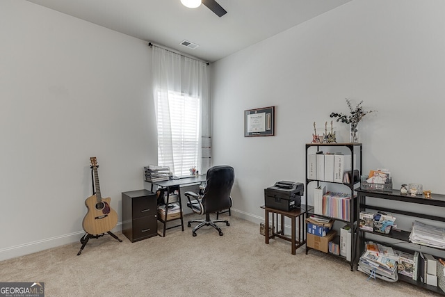 office space with light colored carpet, ceiling fan, and baseboards