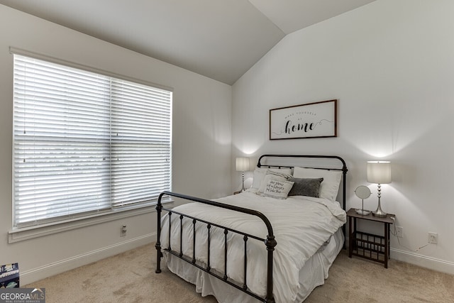 carpeted bedroom with vaulted ceiling and baseboards