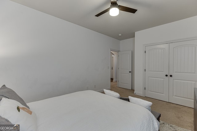carpeted bedroom with a closet, ceiling fan, and baseboards
