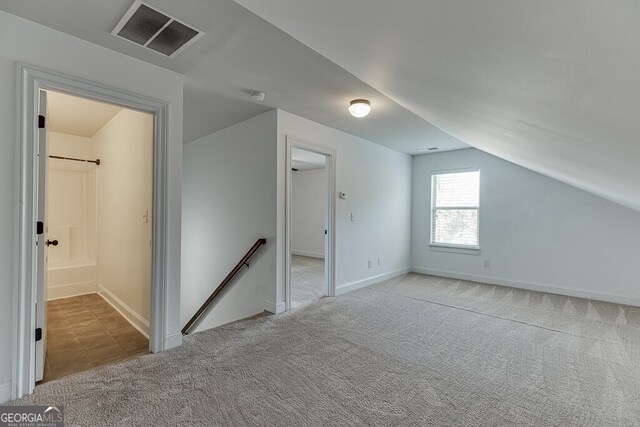 bonus room with lofted ceiling, carpet flooring, and baseboards