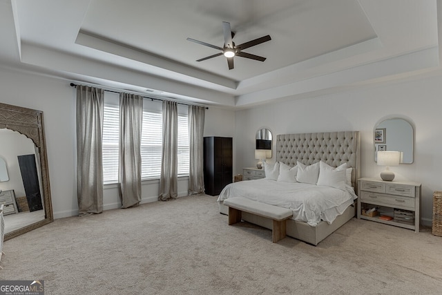 bedroom featuring a raised ceiling, carpet, and ceiling fan
