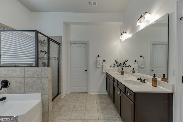 full bathroom featuring a shower stall, a garden tub, double vanity, and tile patterned floors