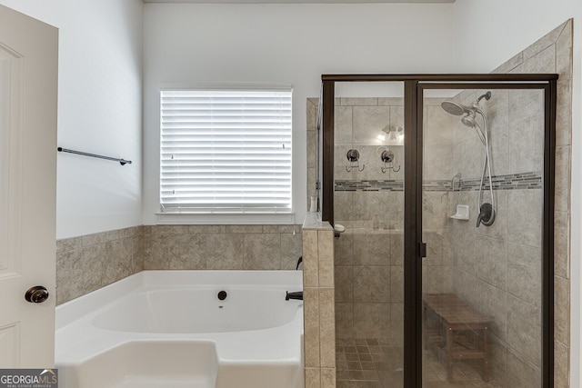 bathroom featuring a garden tub and a shower stall