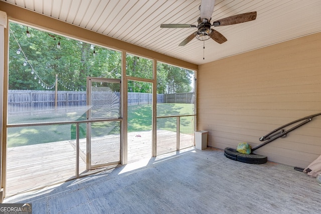 unfurnished sunroom featuring a ceiling fan