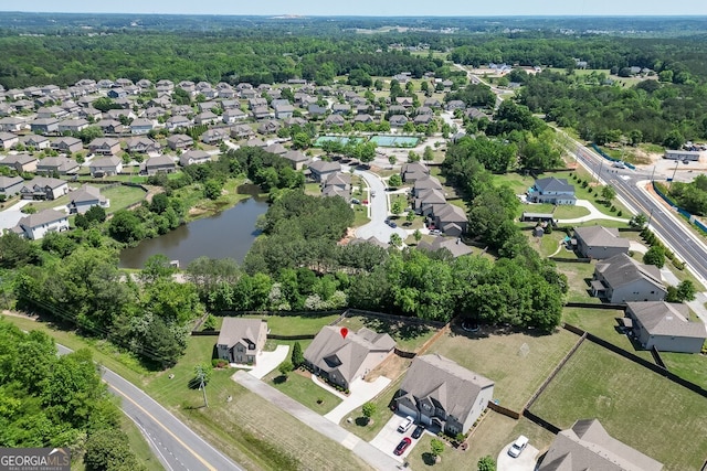view of property location with nearby suburban area, a large body of water, and a forest