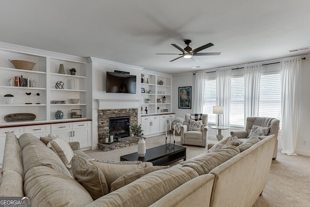 living room with light carpet, ceiling fan, and a stone fireplace