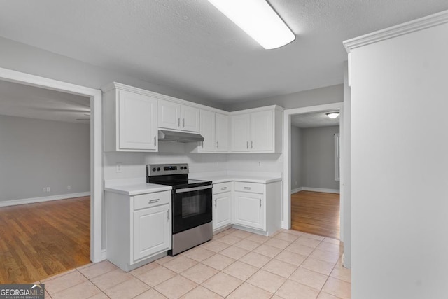 kitchen with stainless steel electric range, under cabinet range hood, light countertops, white cabinetry, and a textured ceiling