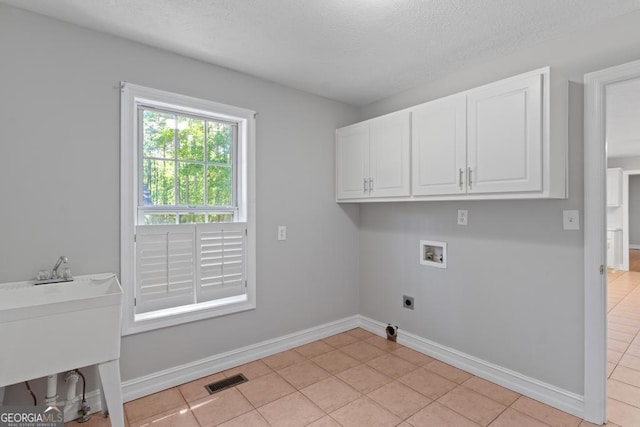 laundry area with cabinet space, hookup for a washing machine, electric dryer hookup, baseboards, and light tile patterned floors
