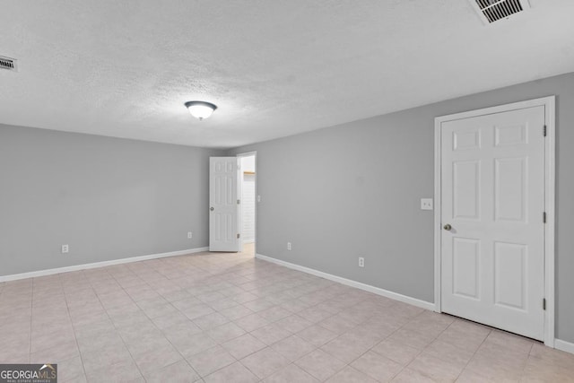 unfurnished room featuring a textured ceiling and baseboards