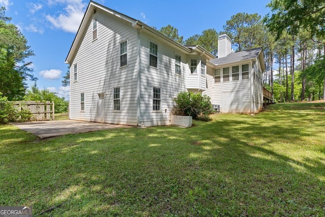 rear view of property featuring a patio area and a chimney