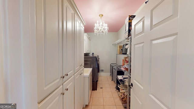 200 N Willow Ct, Alpharetta, GA 30004 - washroom featuring washing machine and dryer, cabinet space, a chandelier, and light tile patterned floors
