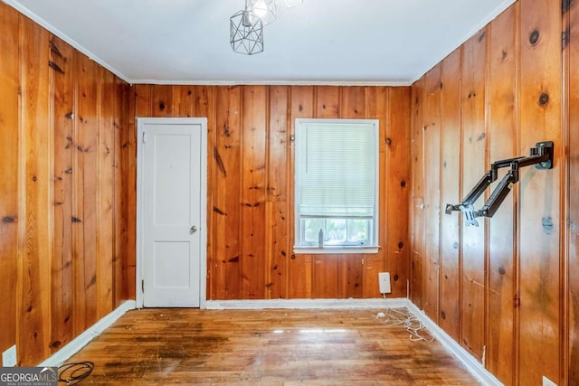 foyer with wood finished floors, wooden walls, and baseboards