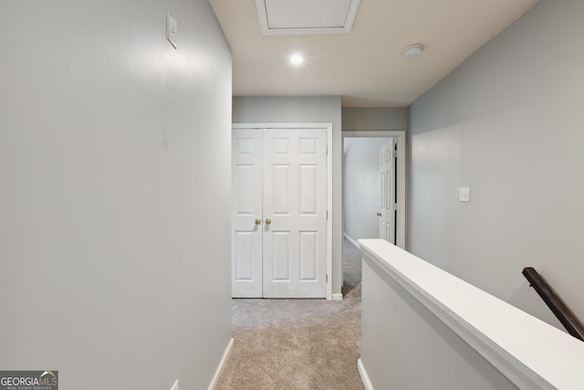 hallway featuring light colored carpet, baseboards, an upstairs landing, and recessed lighting