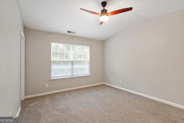 spare room featuring carpet, ceiling fan, baseboards, and vaulted ceiling