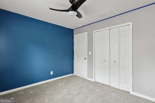unfurnished bedroom featuring carpet, baseboards, a closet, and ceiling fan