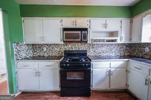1443 Snapfinger Rd, Decatur, GA 30032 - kitchen with stainless steel microwave, black gas range oven, white cabinetry, and dark wood finished floors