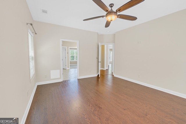 spare room with a ceiling fan, dark wood-style flooring, and baseboards