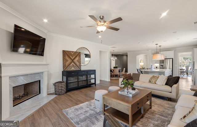 2608 Turnwater St, Hoschton, GA 30548 - living room with ceiling fan, arched walkways, light wood-type flooring, ornamental molding, and recessed lighting