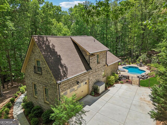 895 Freemanwood Ln, Milton, GA 30004 - view of home's exterior with roof with shingles, fence, brick siding, a gate, and a patio