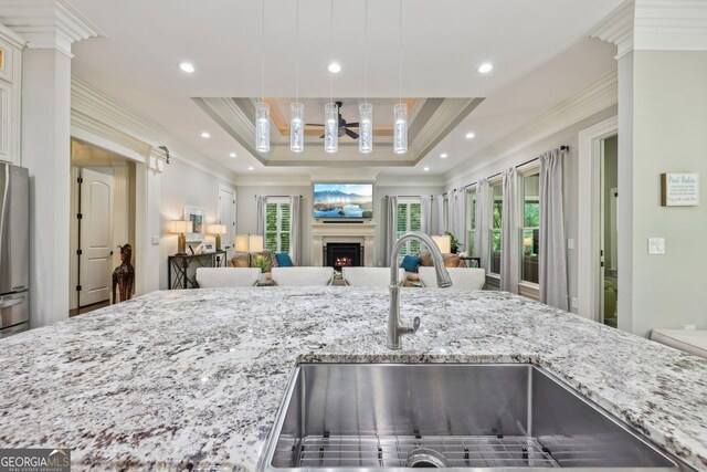 895 Freemanwood Ln, Milton, GA 30004 - kitchen featuring a sink, open floor plan, crown molding, light stone counters, and a tray ceiling
