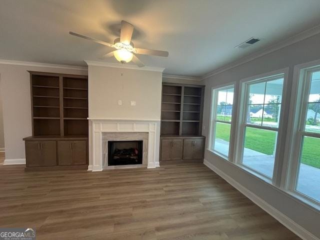 352 Harbour Island Cir, Waverly, GA 31565 - unfurnished living room featuring healthy amount of natural light, baseboards, ornamental molding, wood finished floors, and a fireplace