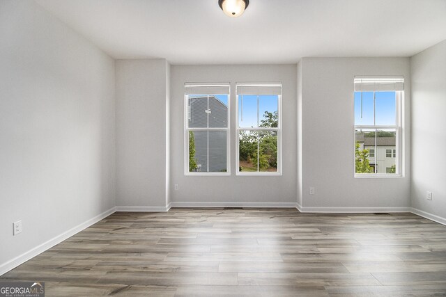 387 Skylar Way SE, Atlanta, GA 30315 - empty room with healthy amount of natural light, wood finished floors, and baseboards