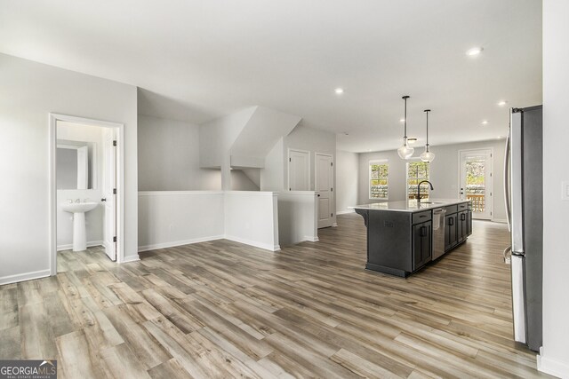 387 Skylar Way SE, Atlanta, GA 30315 - kitchen with stainless steel appliances, a sink, light countertops, open floor plan, and light wood-type flooring
