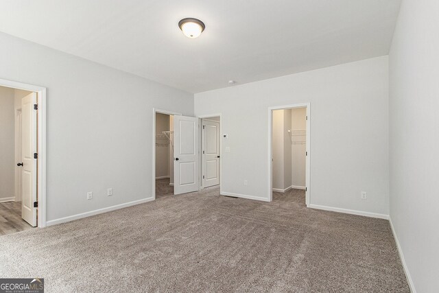 387 Skylar Way SE, Atlanta, GA 30315 - unfurnished bedroom featuring a spacious closet, carpet, a closet, baseboards, and connected bathroom