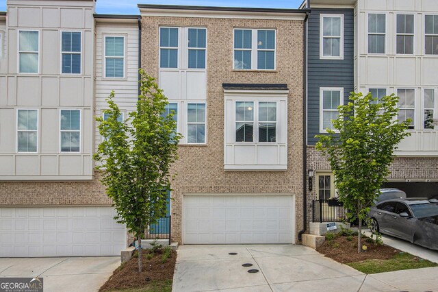 387 Skylar Way SE, Atlanta, GA 30315 - view of property featuring concrete driveway, a garage, and brick siding