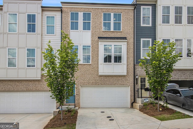 387 Skylar Way SE, Atlanta, GA 30315 - townhome / multi-family property with driveway, an attached garage, and brick siding