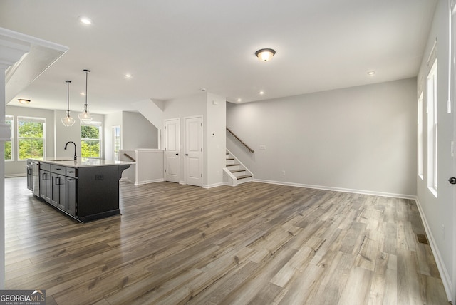 387 Skylar Way SE, Atlanta, GA 30315 - kitchen with light countertops, wood finished floors, a kitchen island with sink, recessed lighting, and hanging light fixtures