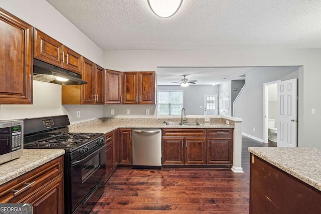 9165 Nesbit Ferry Rd # 9, Alpharetta, GA 30022 - kitchen featuring appliances with stainless steel finishes, under cabinet range hood, dark wood-type flooring, light countertops, and a peninsula