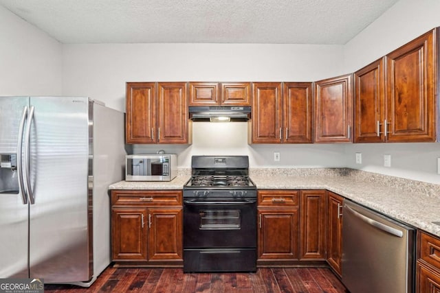 9165 Nesbit Ferry Rd # 9, Alpharetta, GA 30022 - kitchen featuring appliances with stainless steel finishes, under cabinet range hood, light countertops, dark wood-style flooring, and a textured ceiling