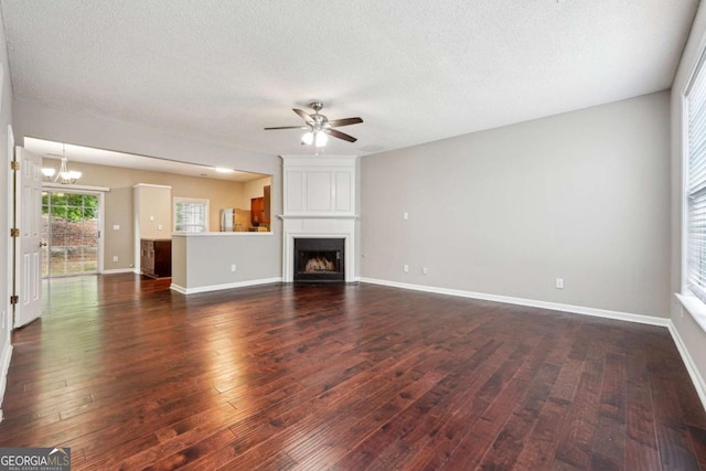 9165 Nesbit Ferry Rd # 9, Alpharetta, GA 30022 - unfurnished living room featuring a chandelier, a ceiling fan, dark wood-style floors, a large fireplace, and a textured ceiling