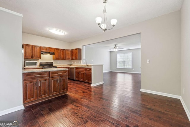9165 Nesbit Ferry Rd # 9, Alpharetta, GA 30022 - kitchen with appliances with stainless steel finishes, under cabinet range hood, light countertops, a peninsula, and dark wood-style floors
