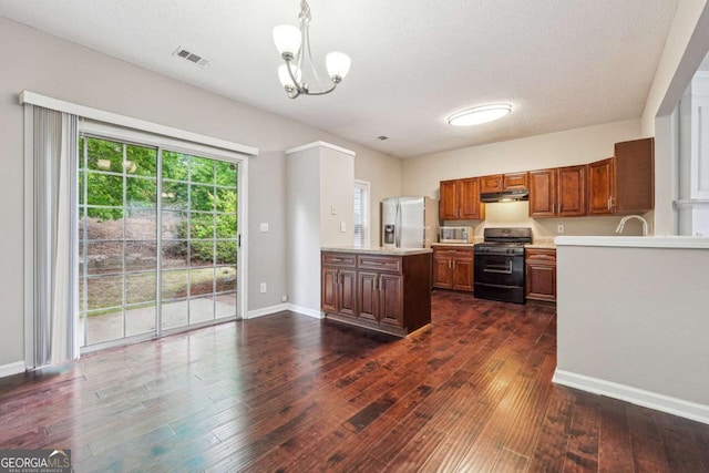 9165 Nesbit Ferry Rd # 9, Alpharetta, GA 30022 - kitchen featuring appliances with stainless steel finishes, light countertops, dark wood-style flooring, a chandelier, and a textured ceiling