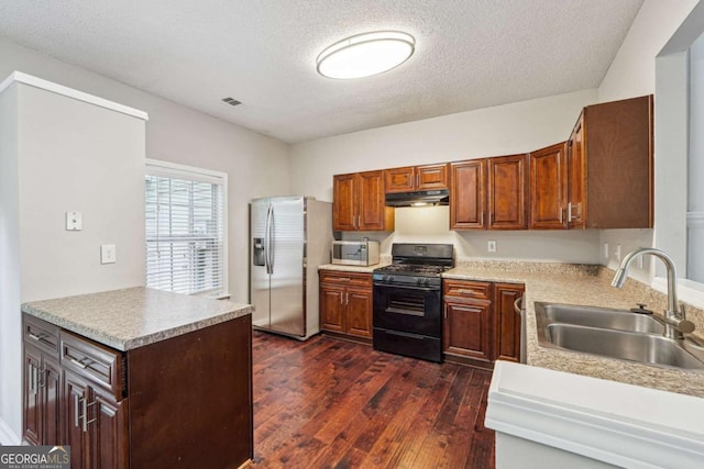 9165 Nesbit Ferry Rd # 9, Alpharetta, GA 30022 - kitchen with stainless steel appliances, dark wood-style flooring, light countertops, a textured ceiling, and under cabinet range hood