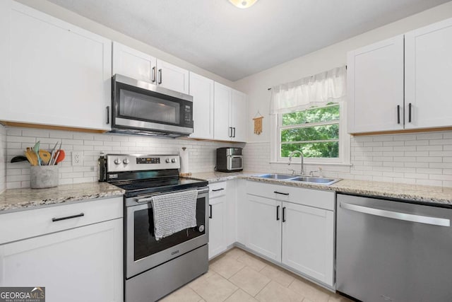 3770 Ponderosa Ln, Powder Springs, GA 30127 - kitchen with appliances with stainless steel finishes, a sink, white cabinetry, light tile patterned flooring, and backsplash