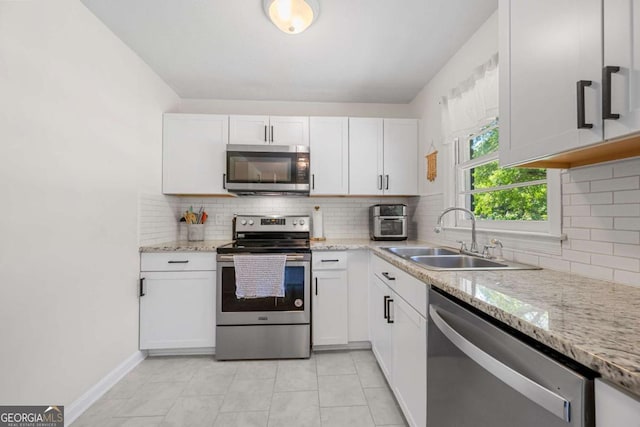 3770 Ponderosa Ln, Powder Springs, GA 30127 - kitchen featuring stainless steel appliances, a sink, white cabinetry, and decorative backsplash