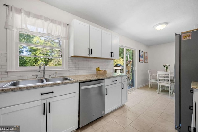 3770 Ponderosa Ln, Powder Springs, GA 30127 - kitchen with stainless steel appliances, a sink, tasteful backsplash, white cabinetry, and light tile patterned flooring