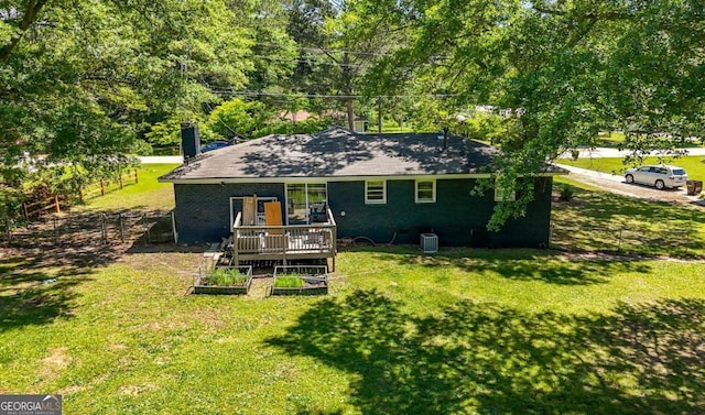 3770 Ponderosa Ln, Powder Springs, GA 30127 - rear view of house featuring a deck, a vegetable garden, a chimney, and brick siding