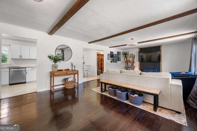 3770 Ponderosa Ln, Powder Springs, GA 30127 - living area with wood finished floors, beam ceiling, a brick fireplace, and baseboards