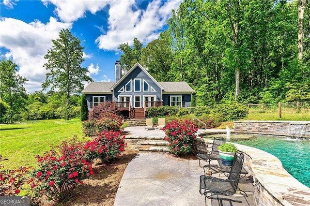163 Thompson Ln, Jasper, GA 30143 - back of property featuring a deck, a chimney, a patio, an outdoor pool, and a lawn