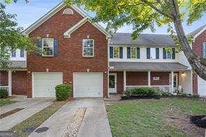 210 Cottonwood Creek Cir, Canton, GA 30114 - view of front of property with concrete driveway, an attached garage, covered porch, and brick siding