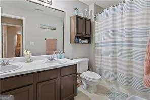210 Cottonwood Creek Cir, Canton, GA 30114 - bathroom with toilet, double vanity, and curtained shower