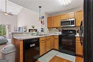 210 Cottonwood Creek Cir, Canton, GA 30114 - kitchen with black appliances, a peninsula, light countertops, pendant lighting, and a ceiling fan