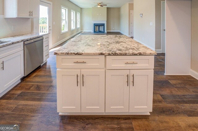 kitchen featuring dishwasher, baseboards, light stone counters, and white cabinets