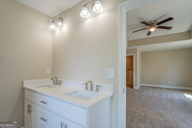 bathroom with ceiling fan, baseboards, and double vanity