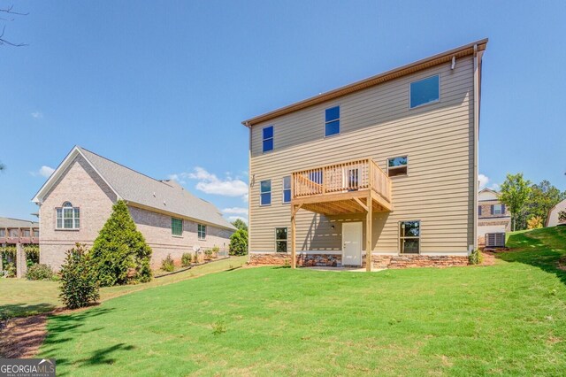 rear view of house with a yard, cooling unit, and a balcony