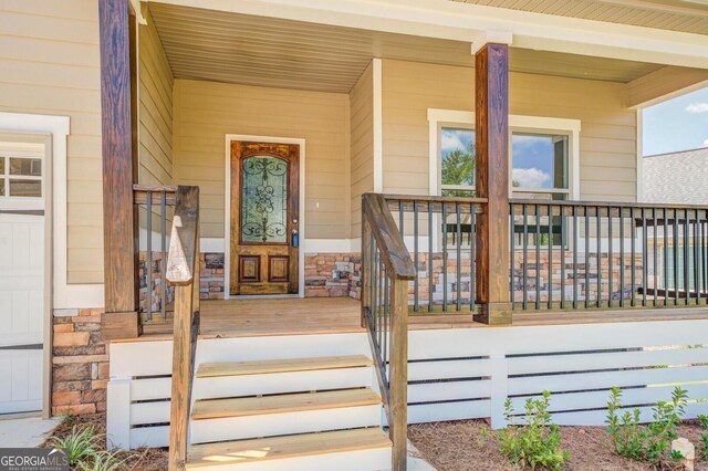 property entrance with stone siding and covered porch